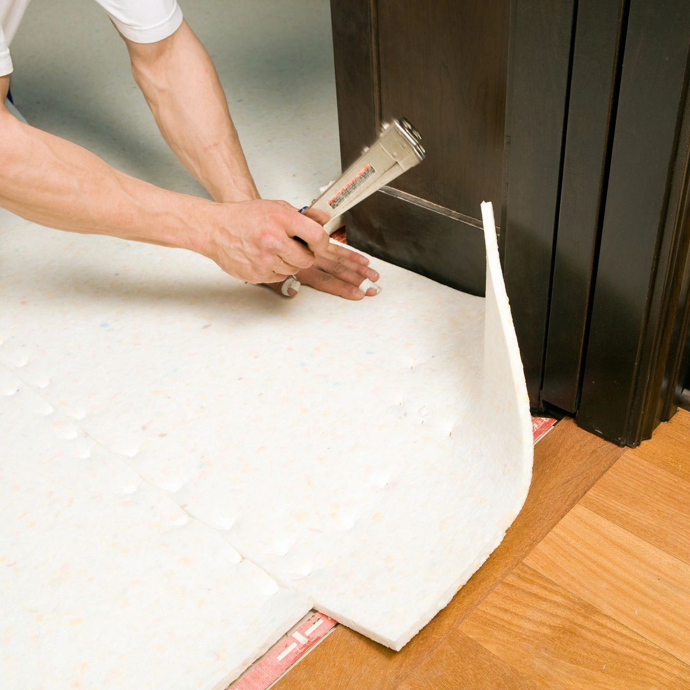 closeup of person installing underlayment - Classic Carpets in Midland, TX